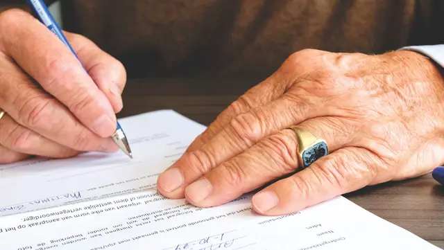 An investor signing documents with a pen